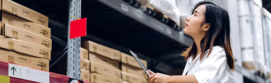 asian woman checking inventory on the warehouse